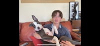 a young man holding a dog on a couch