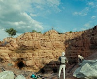 a group of people are standing in a rocky area